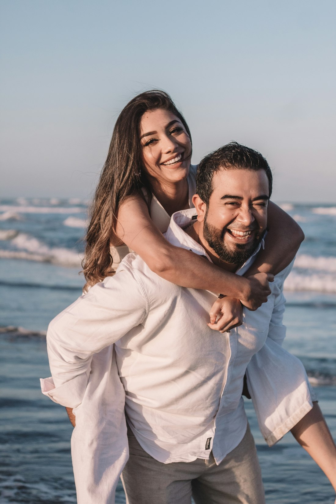 Pareja riendo en la orilla del mar