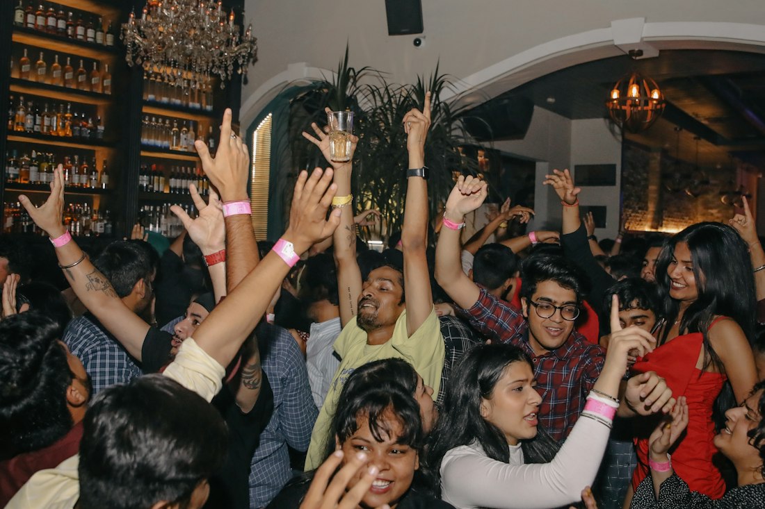 Invitados bailando con los brazos en alto en una fiesta