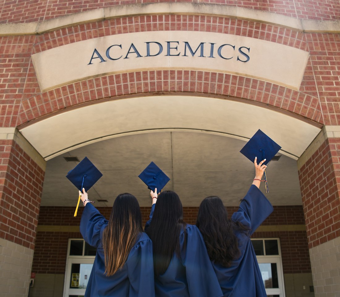Tres graduadas levantan sus birretes